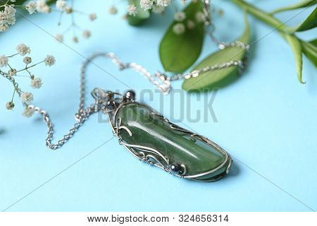 Beautiful Silver Necklace With Nephrite Gemstone And Flowers On Light Blue Background