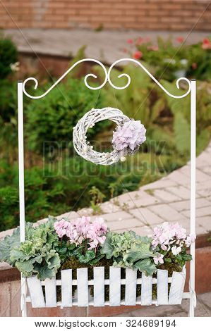 Creative Wedding Floral Aragement, Close-up. Wreath Decoration, A Brick House On The Background. Bac