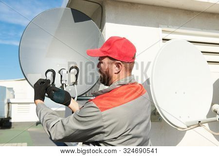 Service worker installing and fitting satellite antenna dish for cable TV