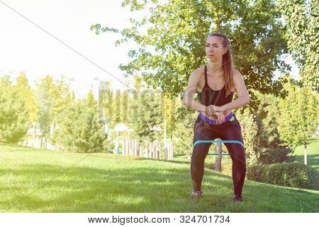 Rubber Squat. Fitness. Athlete Girl, Thlete Exercise At Outside, Woman Fitness. Young Beautiful Woma