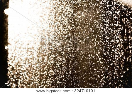 Moisty Wet Window With Water Running Down The Surface. Window Glass After Heavy Rain Lit By The Sett