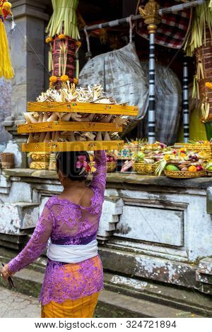 Indonesia Bali, Sept 20 2019, Woman With Fruit Basket On Her Head For Offering In Temple