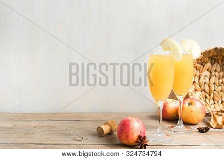 Apple Mimosa Cocktail In Tall Glasses And Organic Apples, Copy Space. Seasonal Fall Drinks For Holid