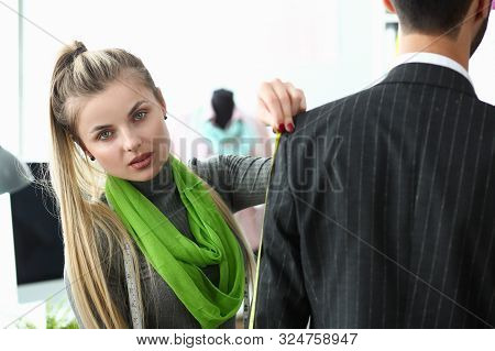 Clothes Creation Process Factory Tailoring Concept. Blond Sempstress Standing Near Male Client Measu