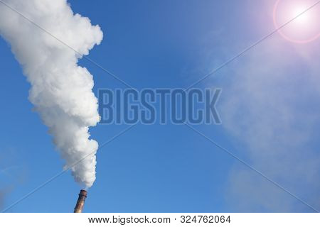 White Smoke Comes From Pipes Against Blue Sky. Problem Harmful Emissions And Air Pollution Of Centra