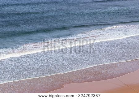 Surfers In The Waves Off Mawgan Porth Beach, North Cornwall, Uk