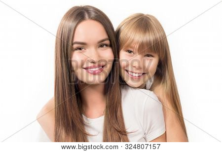 Two sisters - older and younger together. Portrait of beautiful young sisters teenage and adult girls hugging and smiling together, Isolated on white background. Beautiful Siblings, Happy family