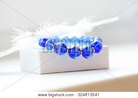 Bright Blue Bracelet Made Of Glass Beads On A White Background.