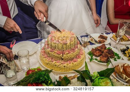 Bride And Groom Cut The Cake At The Wedding