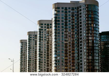 A Row Of Modern High-rise Buildings Against A Clear Blue Sky In Perspective. Urban Background. Urban