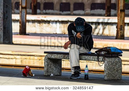 Man Sitting On A Bench, Waiting Train On The Platform Of Bucharest North Railway Station (gara De No