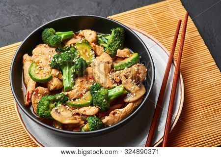 Hunan Chicken In Black Bowl At Dark Slate Background. Hunan Chicken Is Chinese Or Indo-chinese Cuisi
