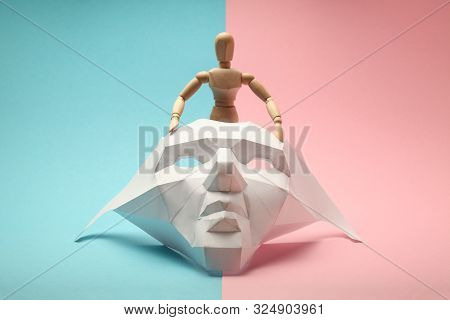 Wooden Figure Of Transgender People Is Hiding Behind Face Mask. Lgbtq Society, Transsexual Lifestyle