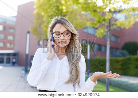 Smart Young Woman Apologizing While Calling Outdoors