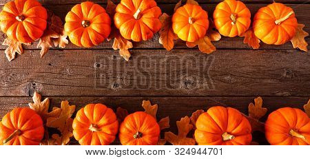 Autumn Double Border Banner Of Pumpkins And Fall Leaves. Above View On A Rustic Wood Background With