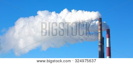 White Smoke Comes From Pipes Against Blue Sky. Problem Harmful Emissions And Air Pollution Of Centra
