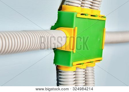 Plastic Electrical Junction Box Is Green, Rectangular Shape, Is Mounted On The Wall In The Residenti