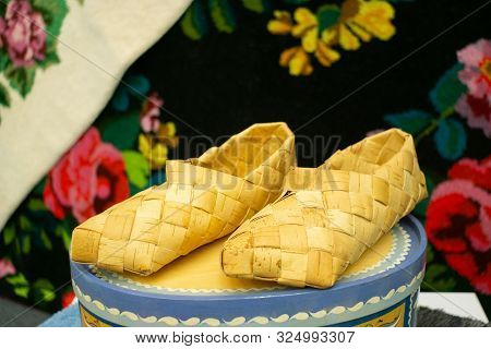 Old Russian Sandals Made Of Bark. Birch Bark Shoes, Traditional Old Russian Shoes Lie On An Old Trad