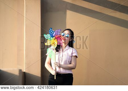 Asian Woman Posts And Play Windmill Toy Colourful Rainbow Colour On The Building Rooftop In Sunset T