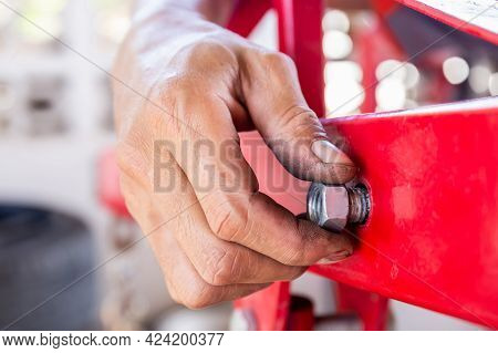 Close Up Of Repair Mechanic Hands Install Bolts & Nuts Of Piping, Worker's Hand Tightens The Nut On 