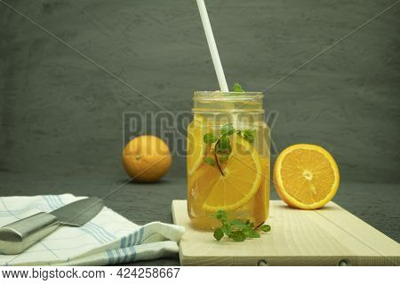 Cool Lemonade Made From Orange And Lime Slices. Orange Cocktail Drink. Background With Space For Tex