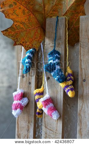 Small Knitten Socks On The Wooden Background