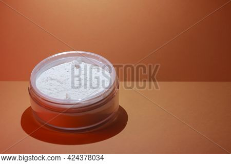 Loose White Face Powder On An Orange Background. Professional Cosmetics