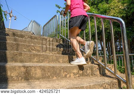 Cropped View Of Fitness Runner Woman Training Herself By Running Up Steps On Staircase In Urban Stre