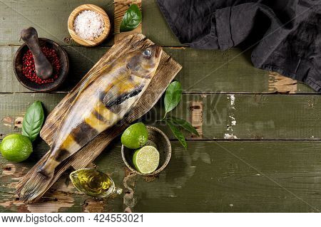Raw Fish Sea Bass Or Lingcod And Seasonings For Cooking It On An Old Plank Background Top View, Free