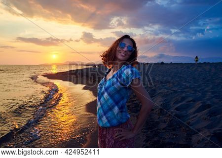 Woman on beach in sunset. People in vacation. Beautiful woman on beach in vacation in sunset. People in vacation. Happy people. Happy beautiful woman in vacation in sunset. Woman silhouette in sunset in vacation. Woman. People. Sunset. Vacation.