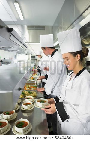 Four chefs working in a busy kitchen at the order station