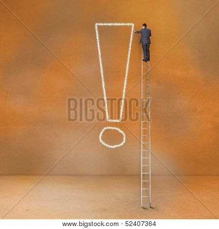Rear view of businessman standing on ladder touching exclamation mark 