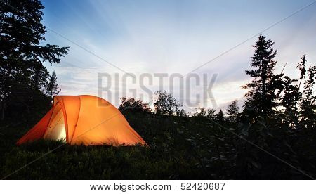 A tent lit up at dusk