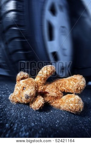 Teddy bear in front of a car