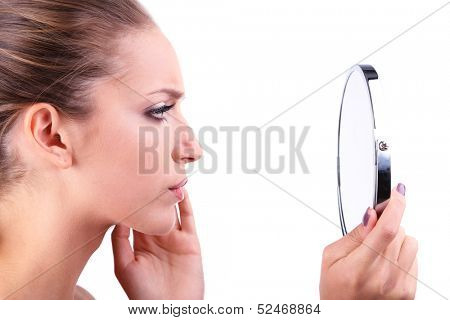 Beautiful girl preens before small mirror isolated on white