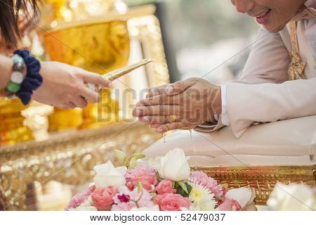 Hands Pouring Blessing Water Into Bride's Bands, Thai Wedding Ceremony