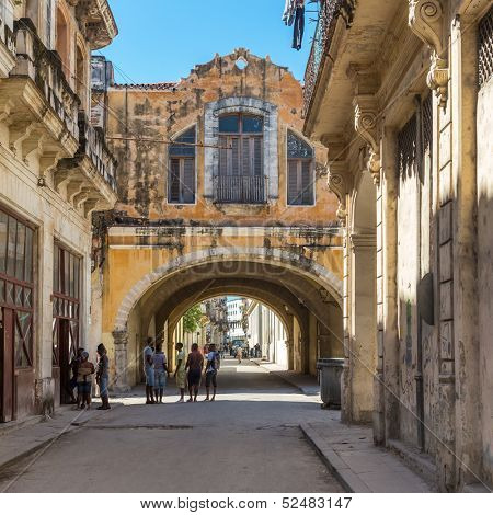HAVANA-OCTOBER 17:People and old shabby buildings in a narrow street October 17,2013 in Havana.With 2.4 million inhabitants and 3.7 in its urban area,Havana is the largest city in the Caribbean