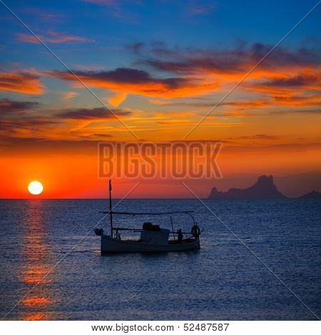 Ibiza sunset Es Vedra view and menorquina fisherboat from Formentera orange sky