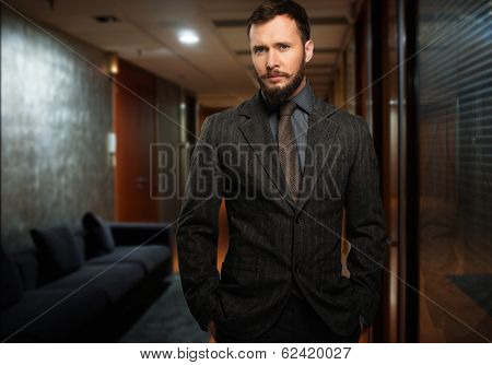 Handsome well-dressed man with beard in a hallway