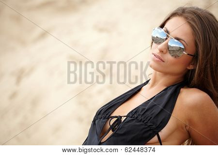 A beautifull caucasian girl lying on the sand,