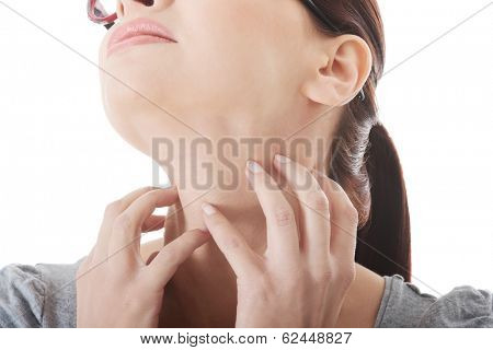 Young woman is scratching her neck. Isolated on white.