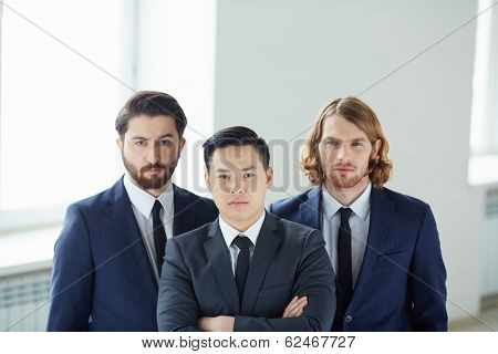 Team of serious businessmen looking at camera