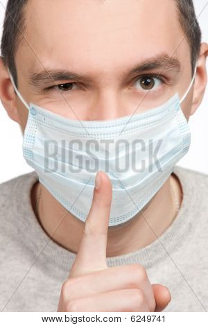 Mand gøre tavshed tegn i beskyttende maske