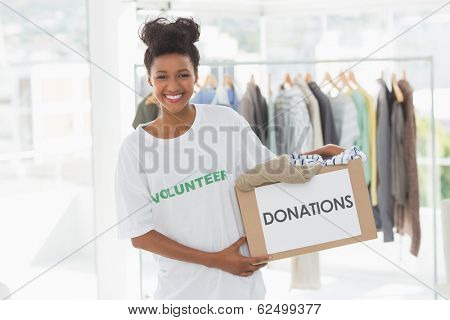 Portrait of a smiling young woman with clothes donation