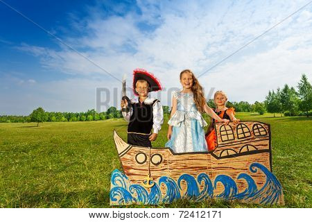 Pirate with sword and two princesses stand on ship