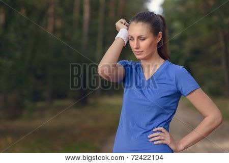 Woman Athlete Wiping Sweat From Her Forehead