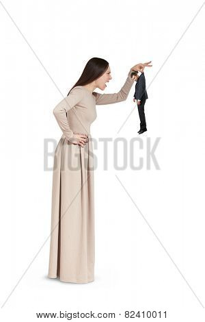 angry young woman holding small man and yelling at him. isolated on white ba?kground