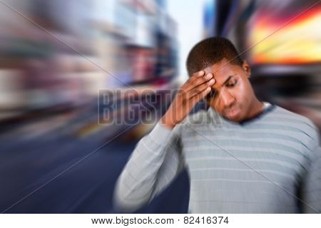 Man with headache against blurry new york street