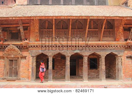 PATAN, NEPAL - APRIL 2014 : A Nepalese woman walking at Patan Museum in Patan, Nepal on 13 April 2014. Patan Museum is an old royal palaces of the former Malla kings of the Kathmandu Valley.