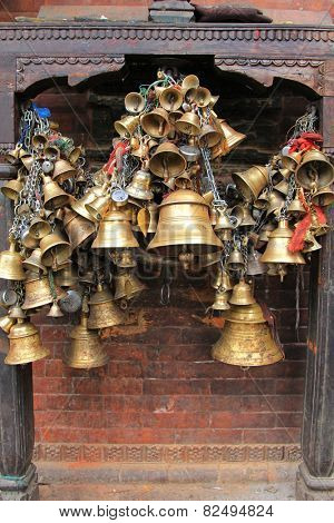 PATAN, NEPAL - APRIL 2014 : Metal sacrificial bells hanging on chain at Kumbeshwar Temple on 13 April 2014 in Patan, Nepal. Bell is one of the worship materials to Hindu Goddess.